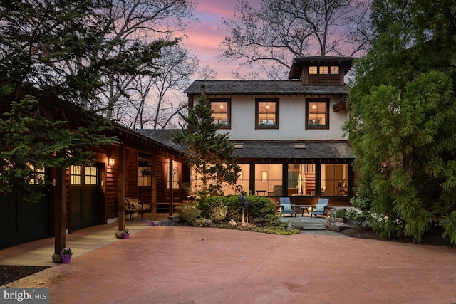 rear view of property with a patio area and stucco siding