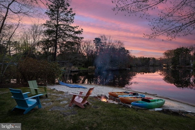 yard at dusk featuring a water view