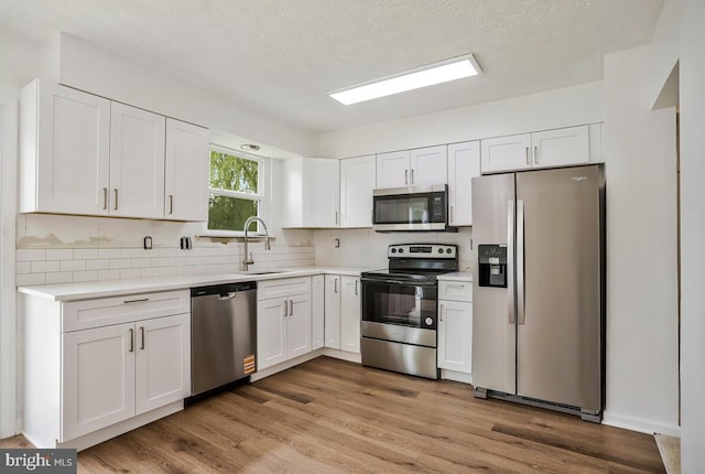 1603 Norwich Dr, Frederick, MD 21701 - kitchen with stainless steel appliances, a sink, white cabinets, light countertops, and backsplash