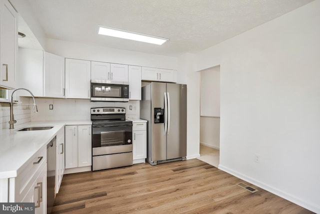 1603 Norwich Dr, Frederick, MD 21701 - kitchen with stainless steel appliances, a sink, light countertops, white cabinetry, and a textured ceiling