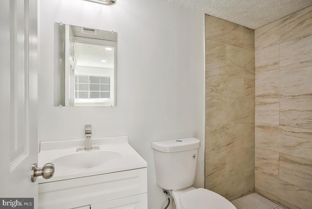1603 Norwich Dr, Frederick, MD 21701 - bathroom with vanity, toilet, tiled shower, and a textured ceiling