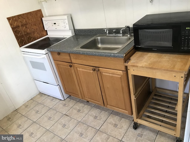 kitchen featuring white electric stove, wood walls, dark countertops, a sink, and black microwave
