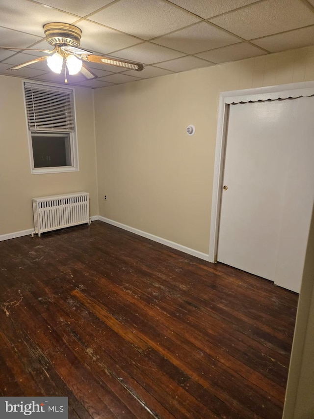 unfurnished room featuring baseboards, radiator, ceiling fan, and hardwood / wood-style flooring