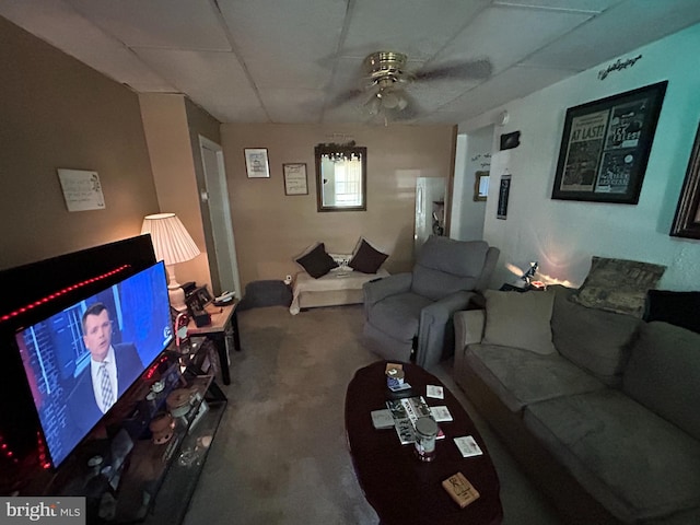 living room featuring a ceiling fan, a drop ceiling, and carpet