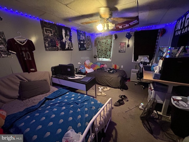 carpeted bedroom with ceiling fan and a paneled ceiling