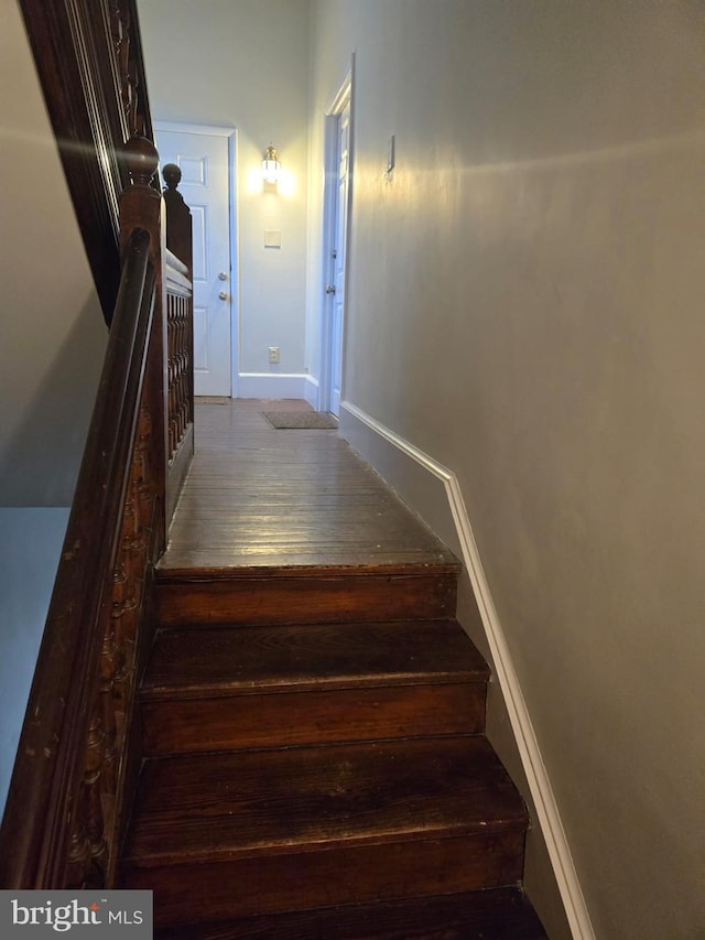 stairs with wood finished floors and baseboards