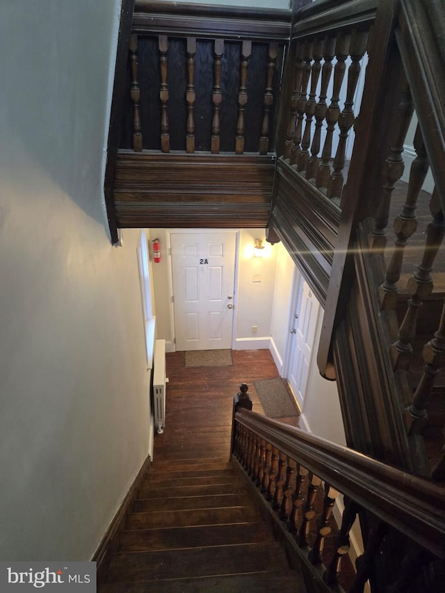 staircase with hardwood / wood-style flooring and baseboards