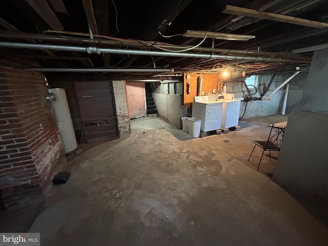 unfinished below grade area with washer and dryer, water heater, and stairs