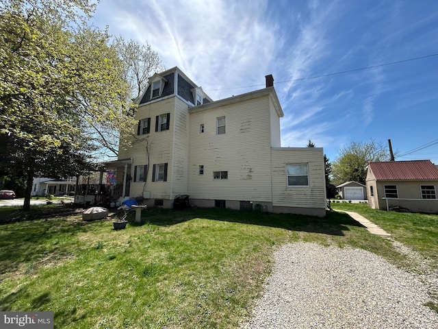 view of property exterior featuring mansard roof and a yard