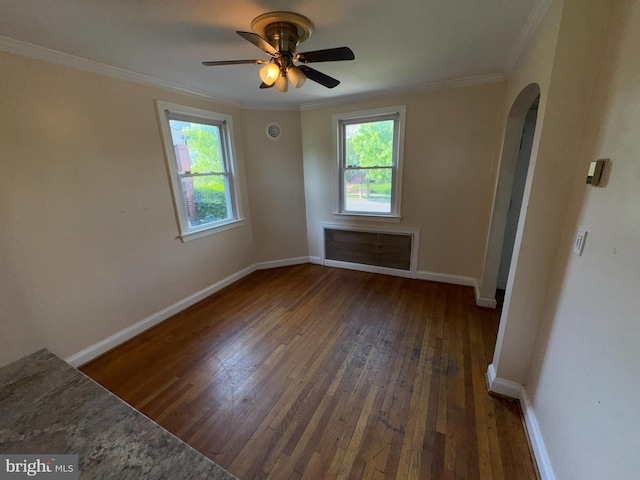 unfurnished room with crown molding, arched walkways, plenty of natural light, and hardwood / wood-style flooring