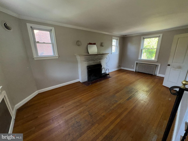 unfurnished living room with a fireplace, hardwood / wood-style flooring, baseboards, radiator heating unit, and ornamental molding