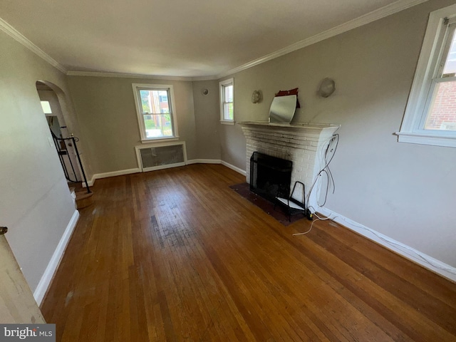 unfurnished living room with baseboards, arched walkways, a fireplace, and hardwood / wood-style flooring