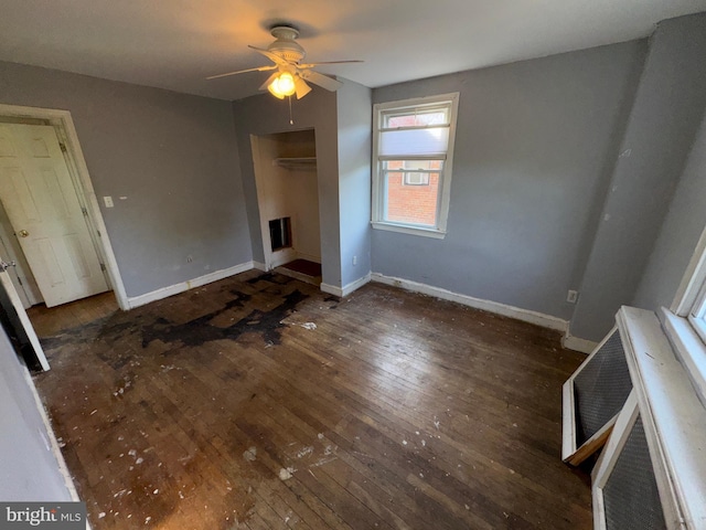 unfurnished bedroom featuring wood-type flooring, baseboards, ceiling fan, and a closet