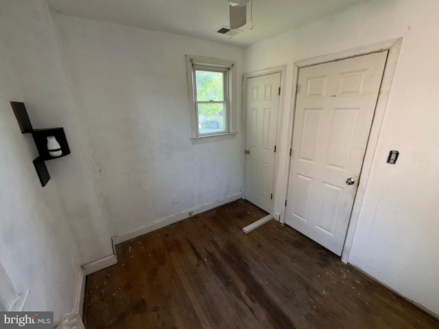 unfurnished bedroom with baseboards, visible vents, and wood finished floors