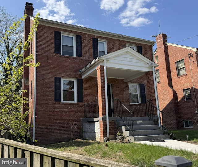 traditional-style house with brick siding and a chimney
