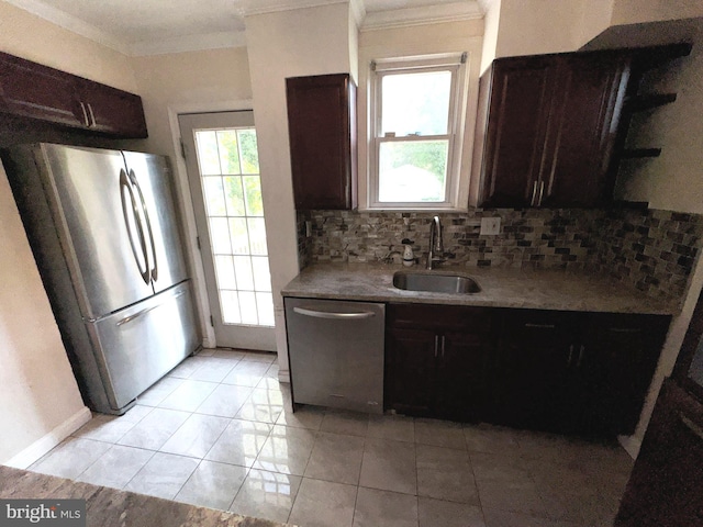 kitchen featuring crown molding, dark brown cabinetry, a sink, stainless steel appliances, and decorative backsplash