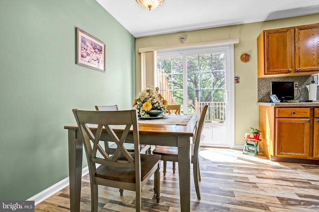 dining space with light wood-style flooring and baseboards