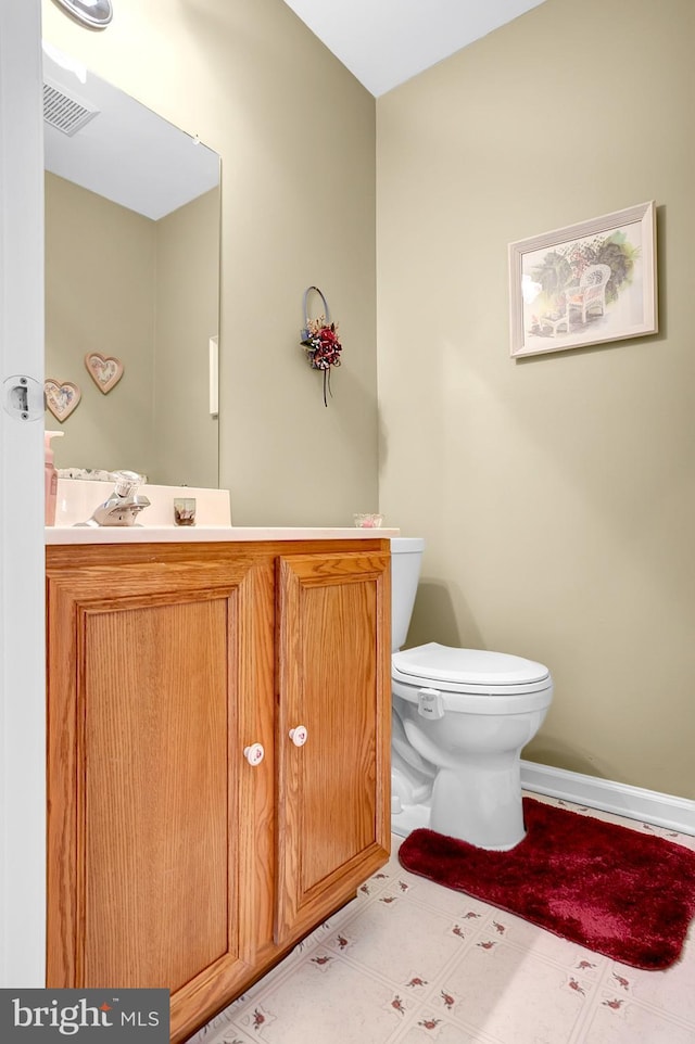 bathroom with toilet, vanity, baseboards, and tile patterned floors