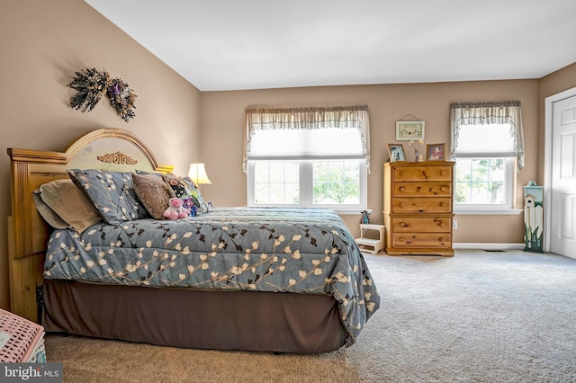 carpeted bedroom with multiple windows and baseboards