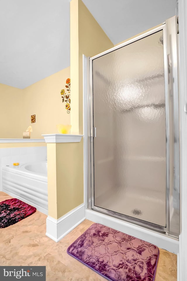 bathroom with a shower stall and a garden tub