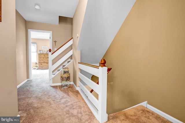 stairway featuring carpet and baseboards