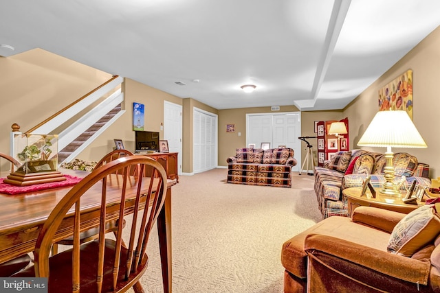 carpeted living room featuring stairs