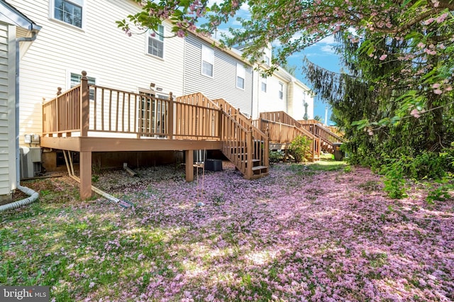 back of house with a wooden deck and stairs