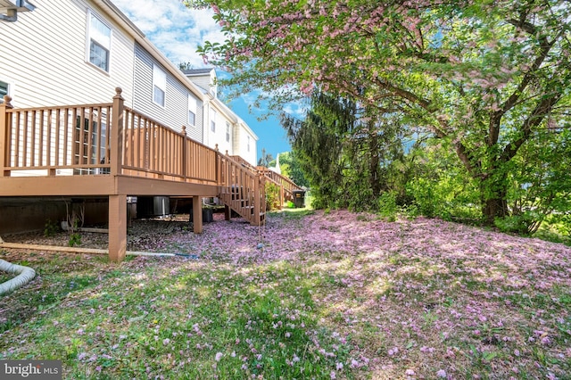 view of yard with a wooden deck and stairs