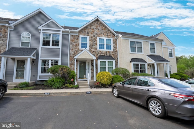 townhome / multi-family property featuring stone siding
