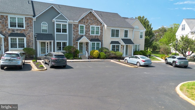 view of front of house with stone siding and uncovered parking