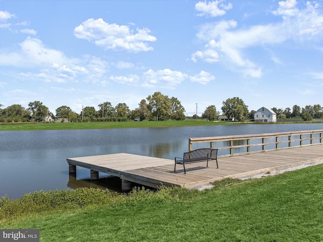 view of dock featuring a lawn and a water view