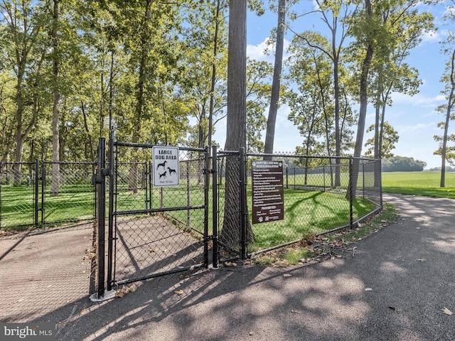 view of gate with a lawn and fence