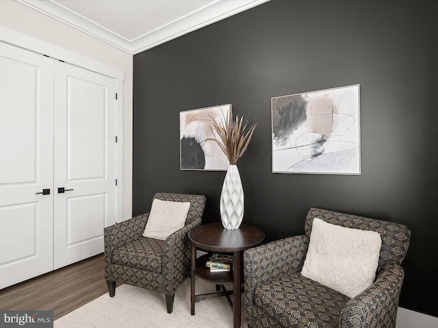 living area featuring ornamental molding and wood finished floors