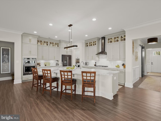 kitchen with crown molding, decorative backsplash, dark wood-style floors, wall chimney range hood, and appliances with stainless steel finishes