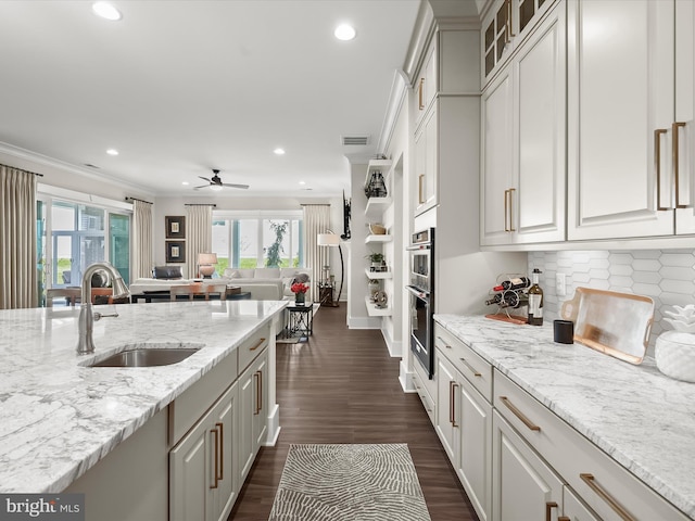 kitchen with a sink, crown molding, recessed lighting, and a wealth of natural light