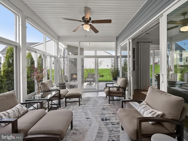 sunroom / solarium with plenty of natural light, ceiling fan, and an outdoor living space