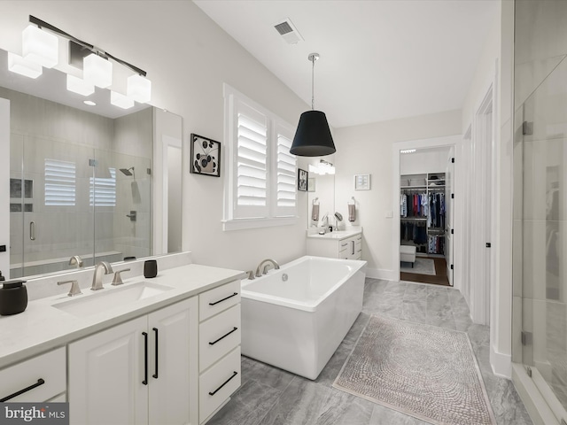 bathroom featuring visible vents, a sink, a stall shower, and two vanities