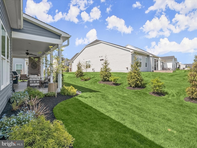 view of yard with ceiling fan, a patio area, and a residential view