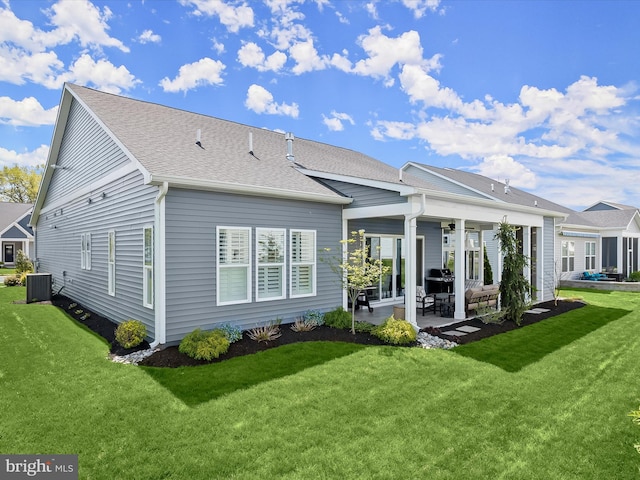 back of property featuring roof with shingles, ceiling fan, central AC unit, a patio area, and a yard