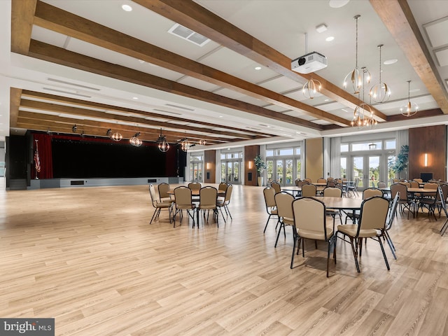 dining space with beamed ceiling, a notable chandelier, wood finished floors, and visible vents