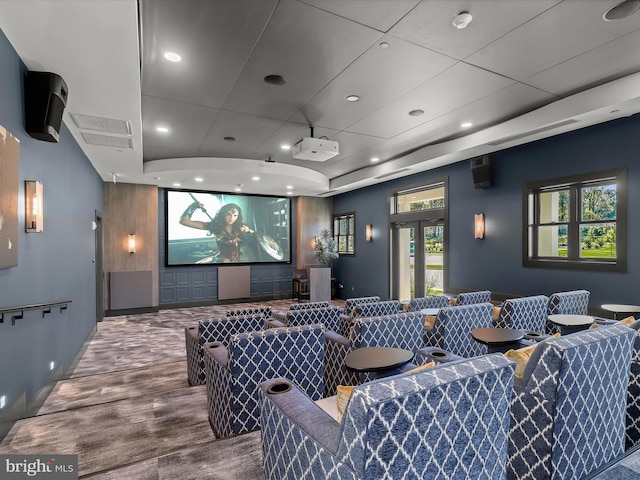 cinema room with visible vents, wood finished floors, baseboards, recessed lighting, and a raised ceiling