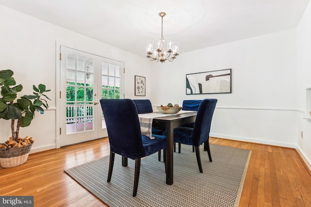 dining area with an inviting chandelier, baseboards, french doors, and light wood-style flooring