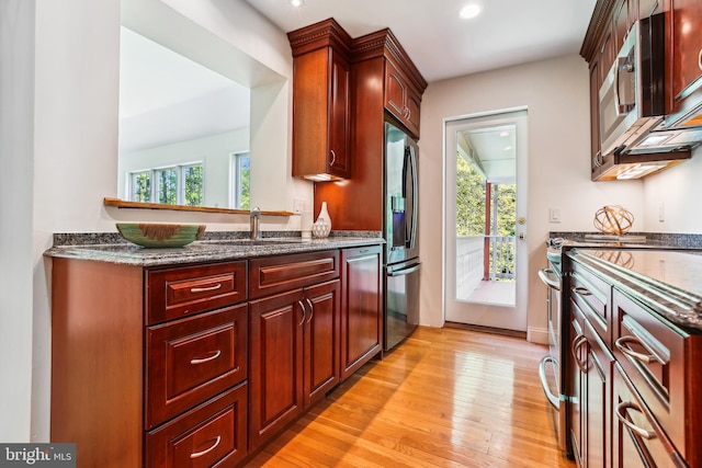 kitchen featuring stainless steel appliances, recessed lighting, plenty of natural light, and light wood-style flooring