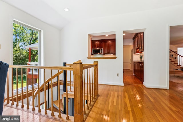 staircase featuring baseboards, vaulted ceiling, recessed lighting, and hardwood / wood-style floors