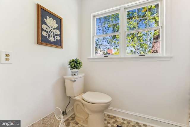 bathroom featuring baseboards, a wealth of natural light, and toilet