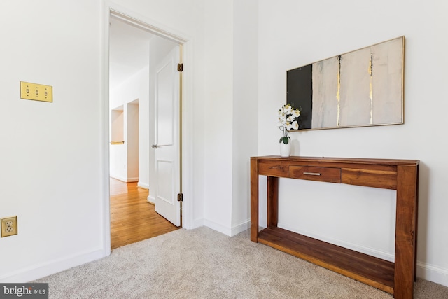 corridor with baseboards and carpet flooring