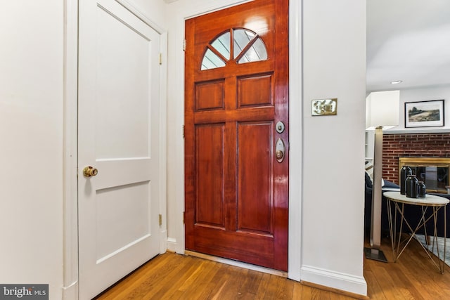 entrance foyer with baseboards, a fireplace, and hardwood / wood-style floors