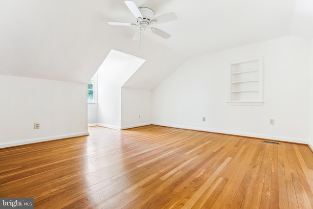 bonus room featuring built in features, a ceiling fan, hardwood / wood-style flooring, and lofted ceiling