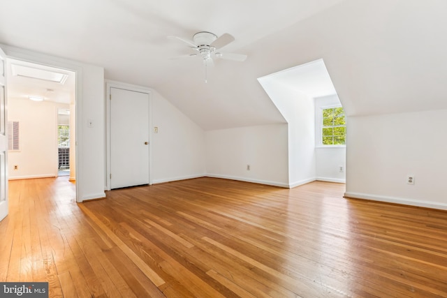 bonus room featuring baseboards, a ceiling fan, light wood-style flooring, and vaulted ceiling