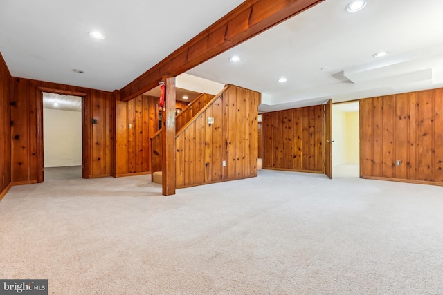 finished basement featuring carpet floors, recessed lighting, wooden walls, and stairway